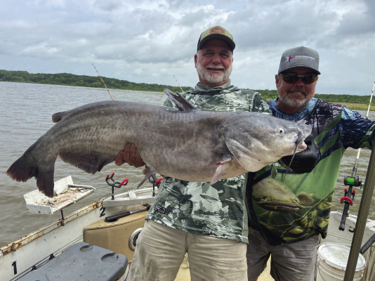 Jeff Rice, left, and Lake Tawakoni catfish guide Tony Pennebaker show off a giant blue catfish landed from shallow water last week. Photo by Luke Clayton