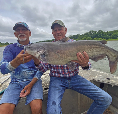 Guide J.C. McCullough (left) and Luke with a big blue catfish last week from the Red River below Lake Texoma. Photo by Jeff Rice